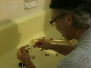 Cleaning a trumpet in the bathtub.