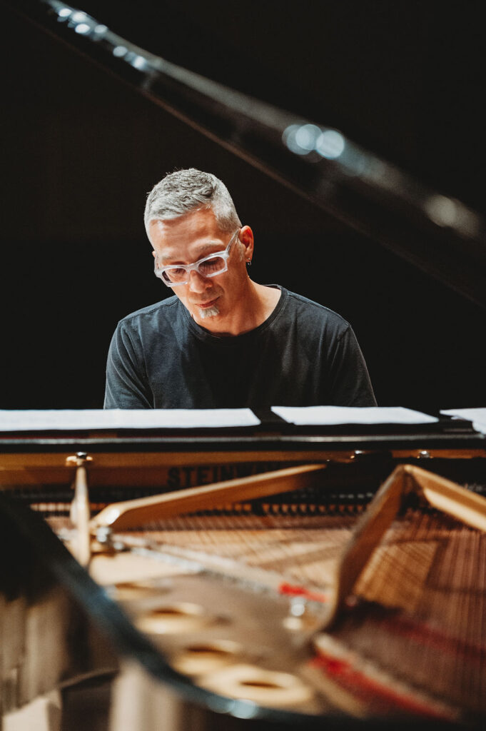 Earl MacDonald seated at a Steinway grand piano.